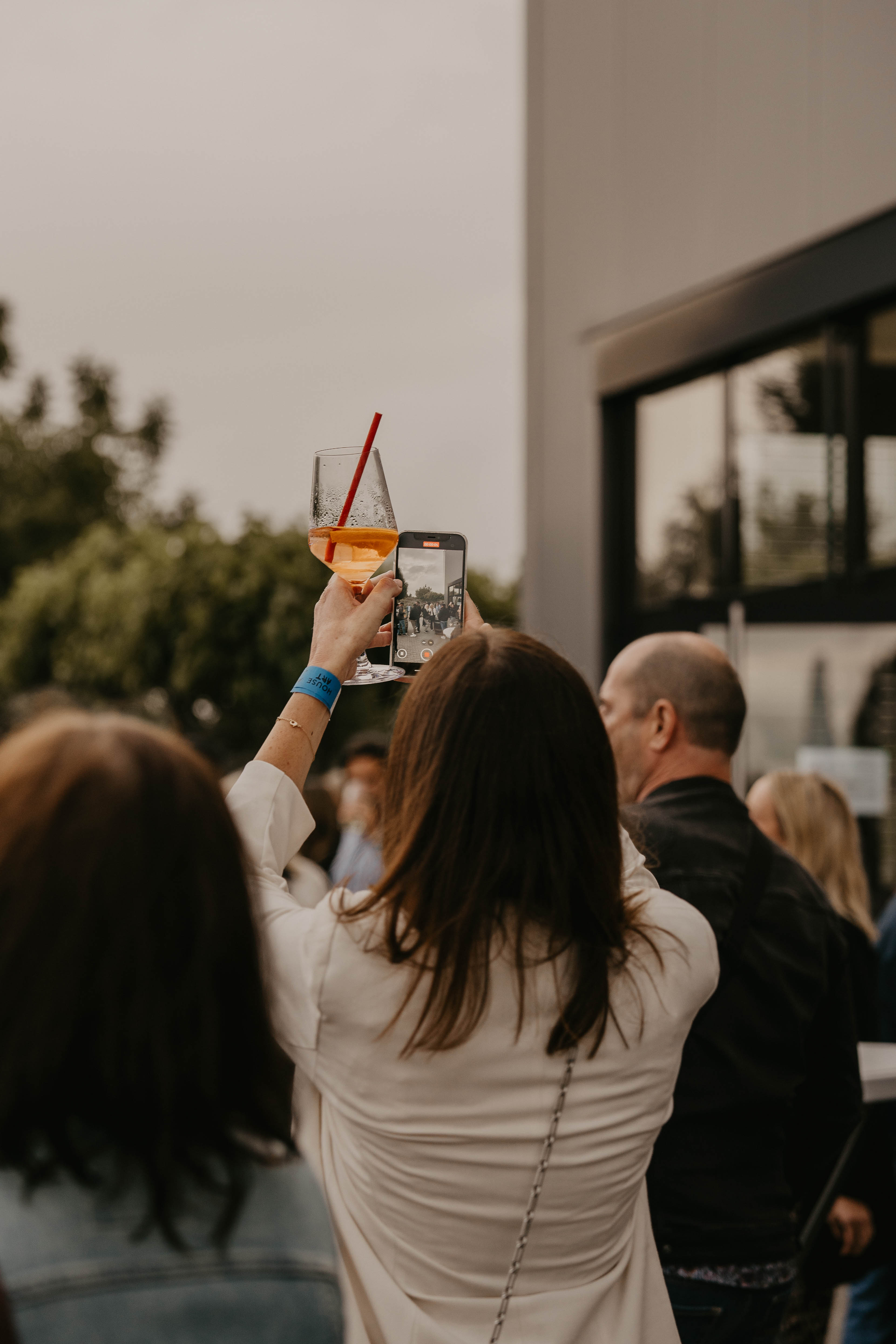 Besucherin fotografiert mit Smartphone und House Art Armband beim Outdoor-Event