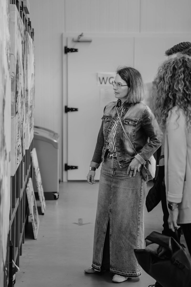 Besucherin betrachtet Kunstwerke an Ausstellungswänden bei der House Art Vernissage